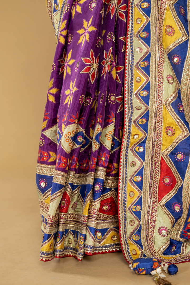 Purple printed saree with gota work highlightment paired with full sleeves contrast blouse