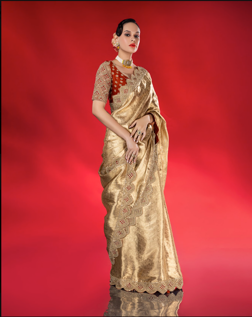 Exude ethereal elegance in this fluid gold tissue Saree