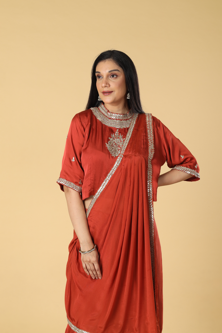 Burnt orange satin organza cowl skirt with gota blouse paired with georgette indowestern