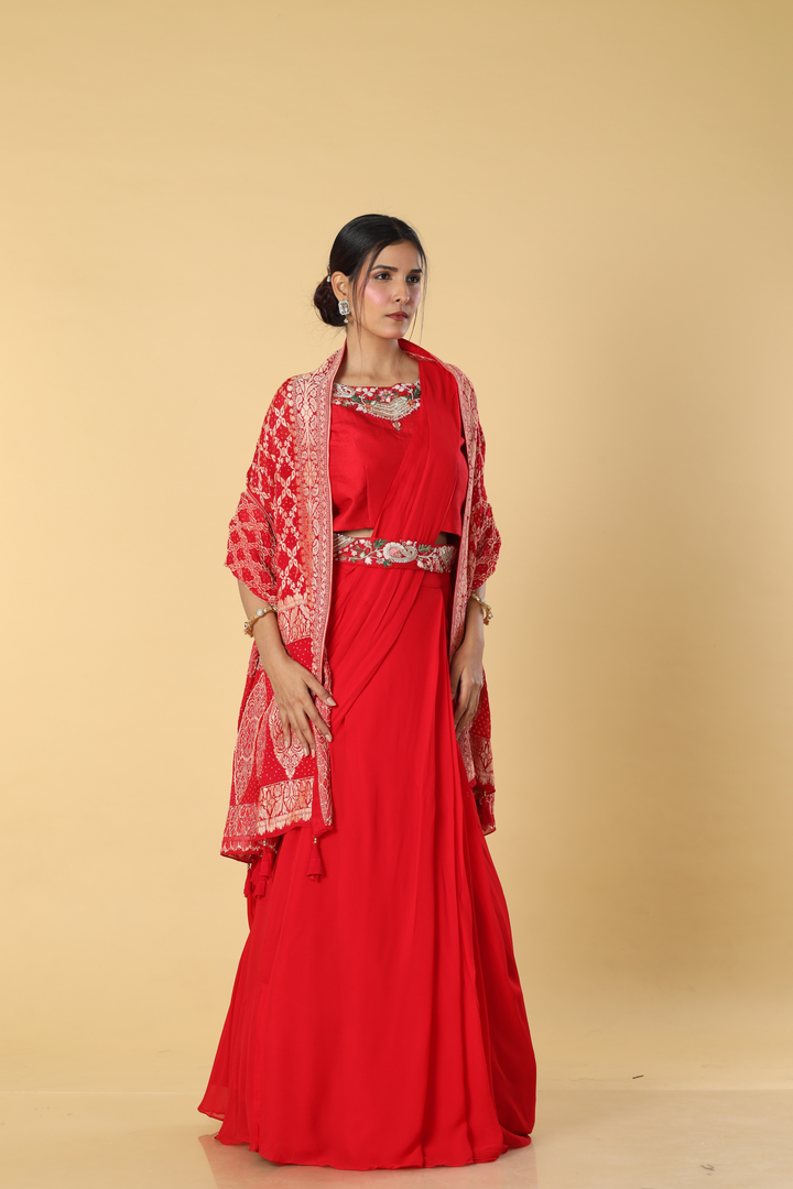 Red D-dupion resham embroidered blouse paired with georgette skirt  and embroidered banarasi bandhej cape