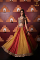 Red and yellow lehenga paired with criss cross style blouse